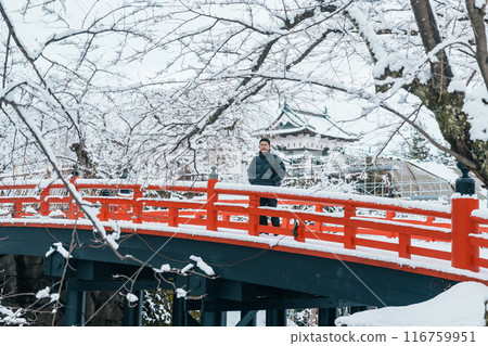 man tourist sightseeing Hirosaki Castle in winter, happy traveler travel Hirosaki city, Aomori Prefecture, Tohoku, Japan. Landmark and famous for tourist attraction. Japan travel and vacation man tourist sightseeing Hirosaki Castle in winter, happy traveler travel Hirosaki city, Aomori Prefecture, Tohoku, Japan. Landmark and famous for tourist attraction. Japan travel and vacation 116759951