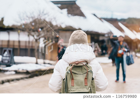 Woman tourist sightseeing Ouchi Juku ancient farmer house village with snow in winter, Traveler travel in Shimogo town, Minamiaizu, Fukushima Prefecture, Tohoku Region, Japan. Landmark and vac Woman tourist sightseeing Ouchi Juku ancient farmer house village with snow in winter, Traveler travel in Shimogo town, Minamiaizu, Fukushima Prefecture, Tohoku Region, Japan. Landmark and vac 116759980