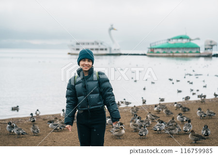 Woman tourist travel Lake Inawashiro in winter, Traveler sightseeing Ducks, Swan and bird in Fukushima Prefecture, Tohoku Region, Japan. Landmark travel and adventure vacation concept Woman tourist travel Lake Inawashiro in winter, Traveler sightseeing Ducks, Swan and bird in Fukushima Prefecture, Tohoku Region, Japan. Landmark travel and adventure vacation concept 116759985