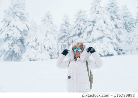 Woman tourist sightseeing Snow monster in Winter day at Mount Zao, Yamagata prefecture, Japan. Happy Traveler walking on powder snow covered in frosty weather. Travel, Adventure and Vacation 116759998