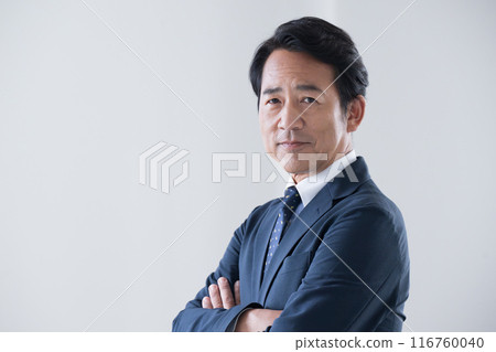 一個50多歲的帥氣商人，看起來就像一個抱著雙臂的商人 116760040