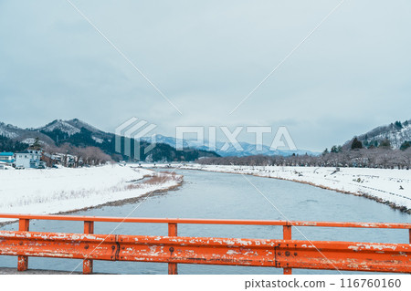 Hinokinai River riverbank with Yokomachi Bridge in winter season. Beautiful sakura trees flowers with snow and mountains locate in Kakunodate town, Semboku District, Akita Prefecture, Japan 116760160