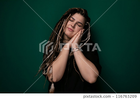 Woman With Dreadlocks Standing in Front of Green Wall Woman With Dreadlocks Standing in Front of Green Wall 116763209