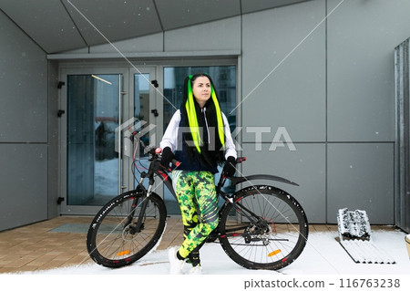 Woman Standing by Bike in Front of Building Woman Standing by Bike in Front of Building 116763238