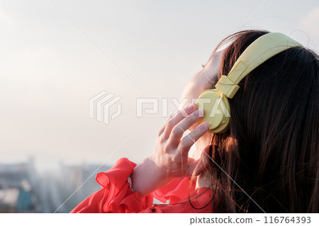 一位女士在博多站的屋頂上一邊聽音樂一邊向外張望 116764393