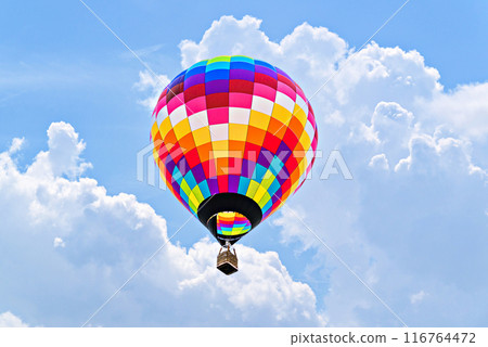 Colorful hot air balloon flying over blue sky with white clouds Colorful hot air balloon flying over blue sky with white clouds 116764472