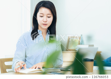 Young woman working on computer in living room 116766053