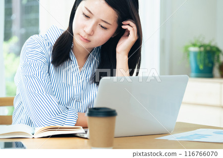 Young woman working on computer in living room Young woman working on computer in living room 116766070