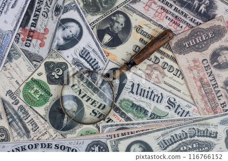 US banknotes and silver certificates with silver dollar coins and magnifying glass US banknotes and silver certificates with silver dollar coins and magnifying glass 116766152