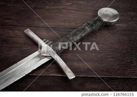Medieval sword on wooden background. Medieval sword on wooden background. 116766155