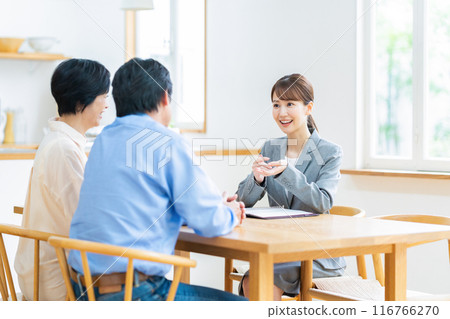 A middle-aged couple consulting with a consultant at home A middle-aged couple consulting with a consultant at home 116766270