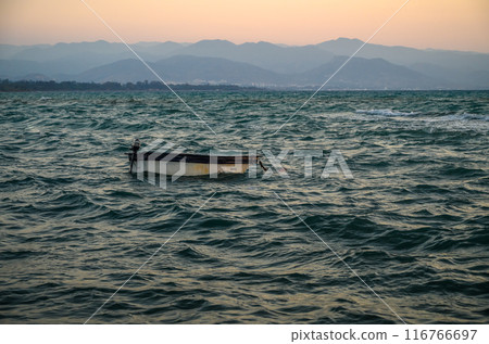 Silhouette of fishing boat on sea beach with sunset background. Silhouette of fishing boat on sea beach with sunset background. 116766697