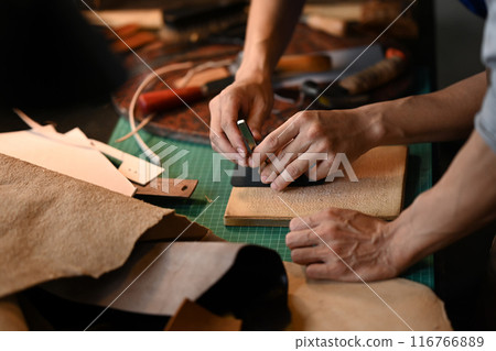 Close up shot two young artisans working with leather in a workshop. Small business and Handmade concept 116766889