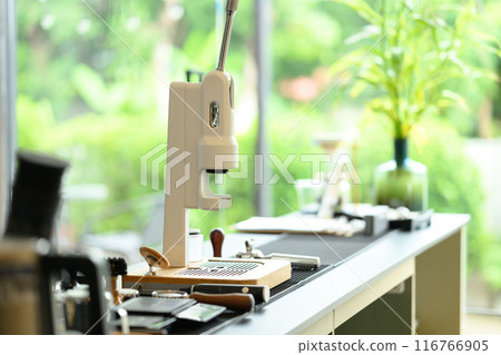 A manual espresso machine and various barista tools on a wooden counter in a minimal cafe 116766905
