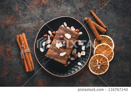 Roll cake in a bowl with dried oranges on a dark background 116767240