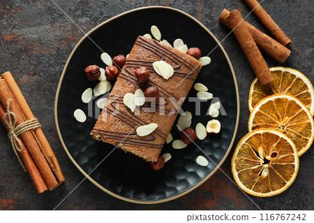 Roll cake in a bowl with dried oranges on a dark background 116767242