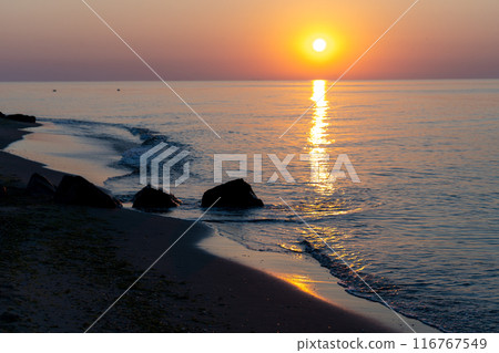 Sunset at the sea. Evening sun and path. Beautiful sky and clouds. Landscape on the coast. Ocean shore. Dawn. Nature. Waves and surf. Relaxation and culm Sunset at the sea. Evening sun and path. Beautiful sky and clouds. Landscape on the coast. Ocean shore. Dawn. Nature. Waves and surf. Relaxation and culm 116767549
