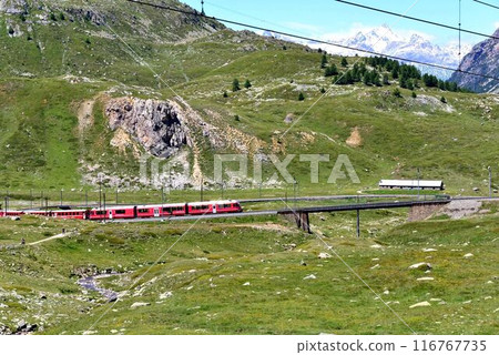 A train has just finished the first S-curve and is heading towards the next curve, passing a large rock. A train has just finished the first S-curve and is heading towards the next curve, passing a large rock. 116767735