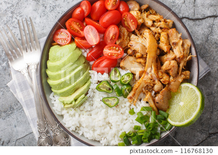 Rice bowl with pulled chicken carnitas, cherry tomatoes, avocado, peppers close-up. Horizontal top view Rice bowl with pulled chicken carnitas, cherry tomatoes, avocado, peppers close-up. Horizontal top view 116768130