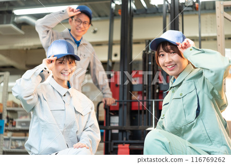 三名穿著工作服的男女工人聚集在堆高機前 三名穿著工作服的男女工人聚集在堆高機前 116769262