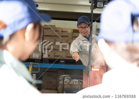 Male worker making a hand signal 116769388