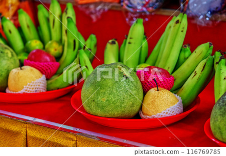 Fruits offering for the Asian gods or Buddha and holy monks in Thailand and Chinese culture, multiple kind of fruits in plastic red tray. Fruits offering for the Asian gods or Buddha and holy monks in Thailand and Chinese culture, multiple kind of fruits in plastic red tray. 116769785