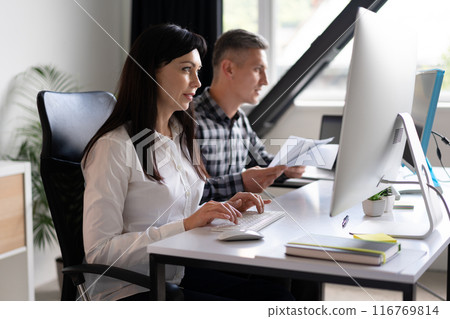 Focused Office Team Working On Computer And Analyzing Documents 116769814