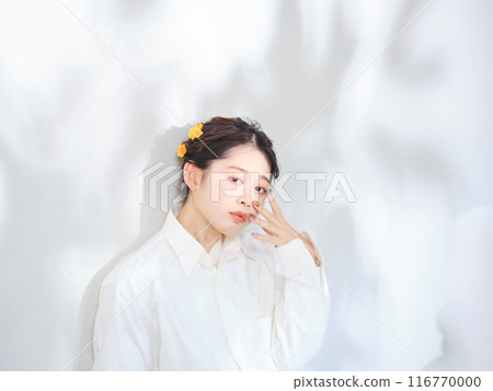 A woman standing in the sunlight filtering through the trees A woman standing in the sunlight filtering through the trees 116770000