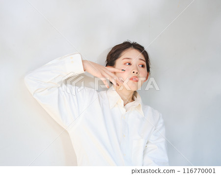 一個女人站在透過樹林的陽光下 116770001