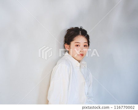 一個女人站在透過樹林的陽光下 一個女人站在透過樹林的陽光下 116770002