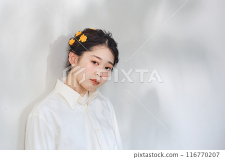 A woman standing in the sunlight filtering through the trees A woman standing in the sunlight filtering through the trees 116770207
