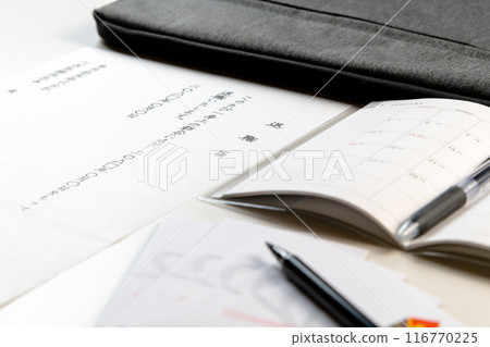 Handwritten resignation letters and a new schedule book are collected on a white desk, along with a farewell gift envelope and a brush pen. Handwritten resignation letters and a new schedule book are collected on a white desk, along with a farewell gift envelope and a brush pen. 116770225