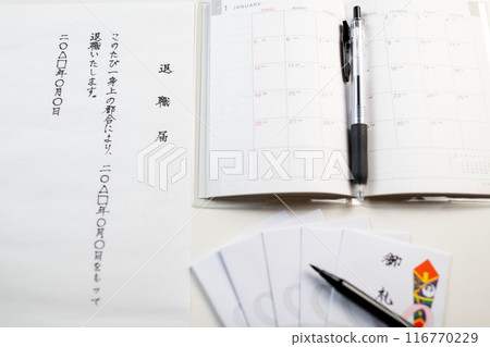 New planners and envelopes for sorting, neatly arranged, and a handwritten letter of resignation 116770229