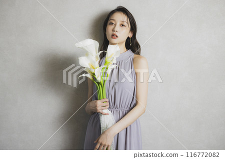 Woman holding a bouquet of calla lilies Woman holding a bouquet of calla lilies 116772082
