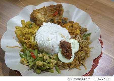 Nasi ayam campur with fragrant rice, tender chicken, and an assortment of colorful side dishes. Nasi ayam campur with fragrant rice, tender chicken, and an assortment of colorful side dishes. 116773070