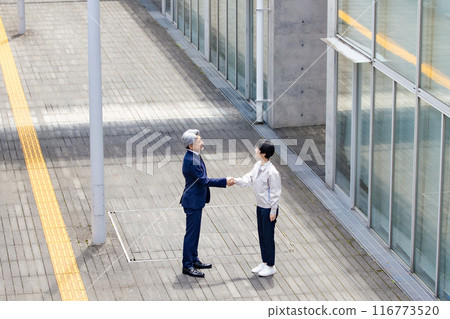 Businessman and engineer shaking hands in the hallway 116773520