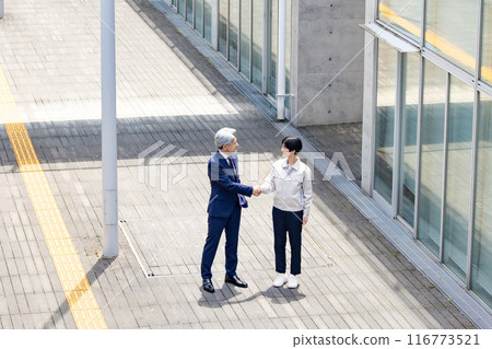 Businessman and engineer shaking hands in the hallway 116773521