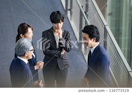 A female business person who is worried alone in a group A female business person who is worried alone in a group 116773529