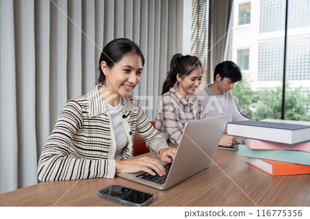 Group of Happy Student Studying Together in a Modern Library with Laptops and Books 116775356