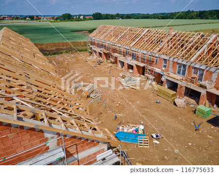 Aerial view of new house construction project in suburban area. Aerial view of new house construction project in suburban area. 116775633