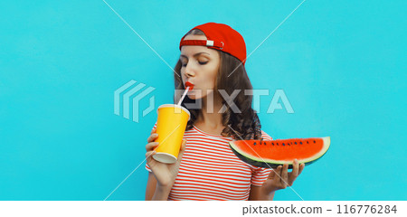 Summer portrait of young woman drinking juice with juicy slice watermelon fruit on blue background Summer portrait of young woman drinking juice with juicy slice watermelon fruit on blue background 116776284