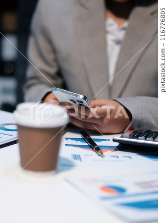 Business woman using calculator and writing make note with calculate. Woman working at office with laptop and documents on his desk 116776805