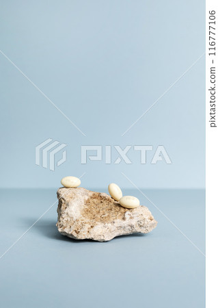 Progesterone Capsules On Stone, Blue Background. Natural Product Concept. Mockup Menopausal Hormone Therapy, Oral Route. Menopause. Cycle Changes. Vertical Copy Space. Design Progesterone Capsules On Stone, Blue Background. Natural Product Concept. Mockup Menopausal Hormone Therapy, Oral Route. Menopause. Cycle Changes. Vertical Copy Space. Design 116777106