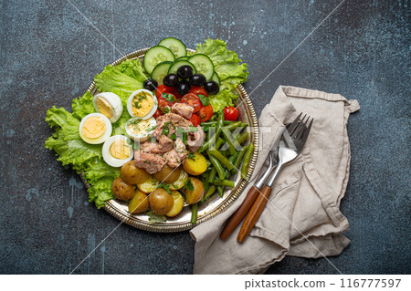 Nicoise salad with tuna, olives, green beans, tomatoes and quail eggs on a bed of lettuce Nicoise salad with tuna, olives, green beans, tomatoes and quail eggs on a bed of lettuce 116777597