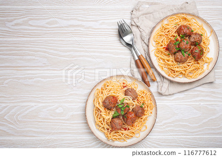 Two plates of delicious spaghetti with meatballs served on white wooden table top view copy space 116777612