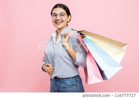 Cheerful woman wearing glasses shirt and jeans holding digital tablet and shopping bags Cheerful woman wearing glasses shirt and jeans holding digital tablet and shopping bags 116777717