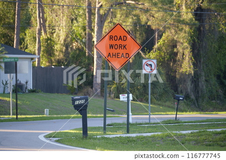 Yellow protective barrier at street construction site. Warning road sign about utility work 116777745