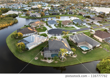 Waterfront single family homes in Florida residential area at sunset. Real estate development in American suburbs Waterfront single family homes in Florida residential area at sunset. Real estate development in American suburbs 116777782