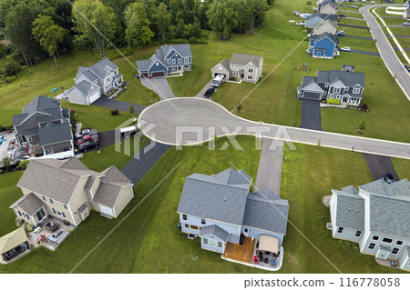 Low-density two story private homes with large lot size and green grassy lawns in summer season. Rural residential suburbs with upscale suburban houses outside of Rochester, New York 116778058