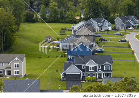 Low-density two story private homes in rural residential suburbs outside of Rochester, New York. Upscale suburban houses with large lot size and green grassy lawns in summer season Low-density two story private homes in rural residential suburbs outside of Rochester, New York. Upscale suburban houses with large lot size and green grassy lawns in summer season 116778059